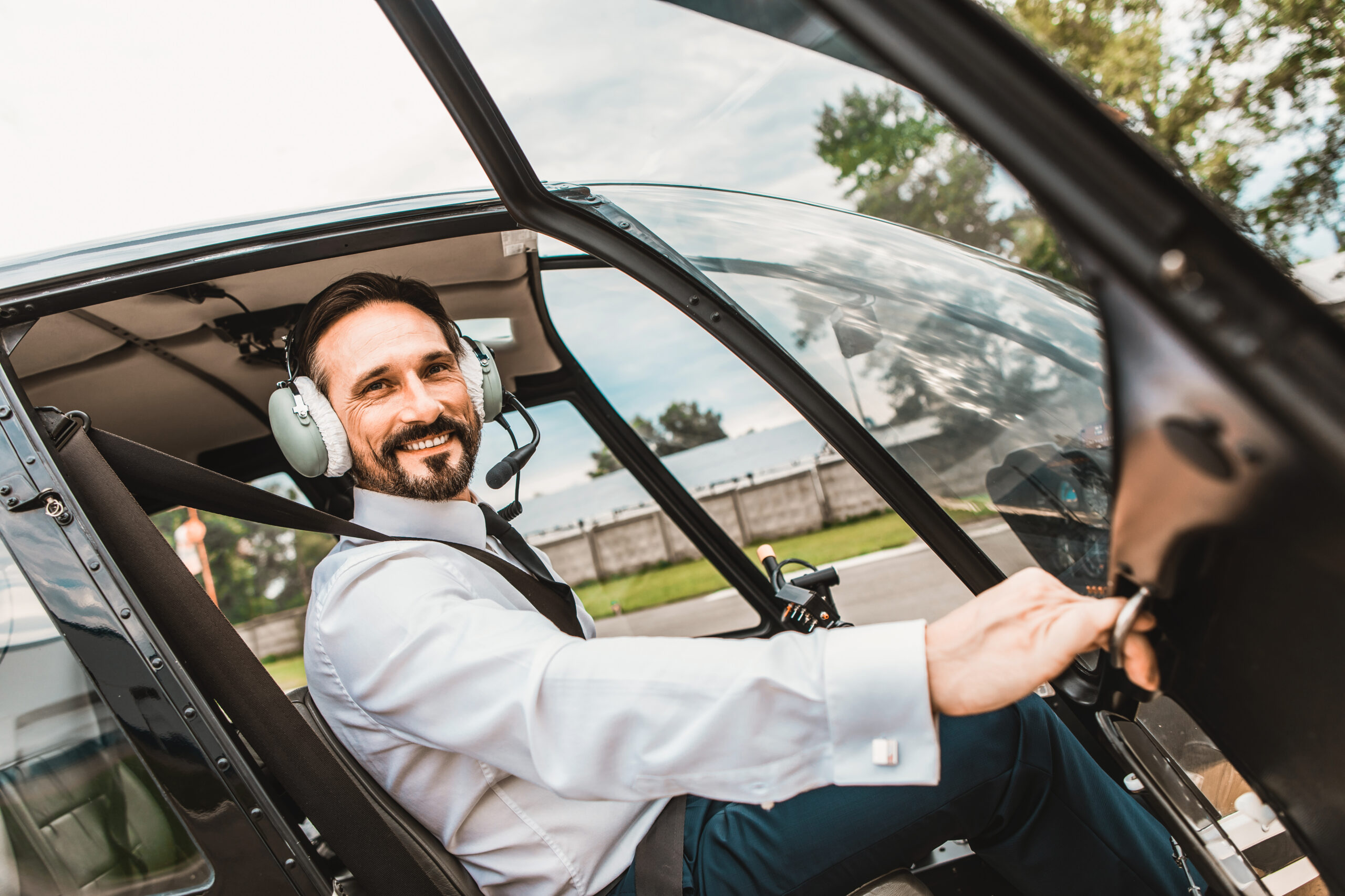 Emotional,Confident,Pilot,Sitting,In,The,Helicopter,And,Smiling,While